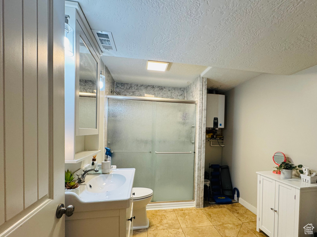 Full bath featuring vanity, tile patterned flooring, a shower stall, toilet, and a textured ceiling