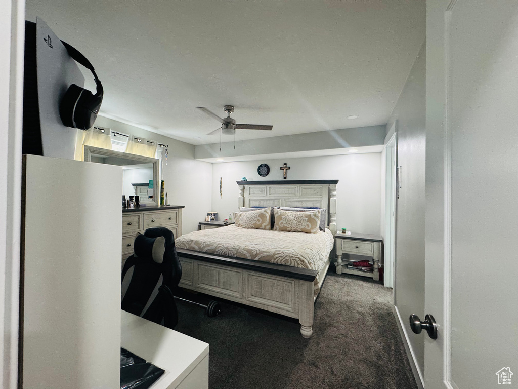Bedroom featuring dark carpet and a ceiling fan