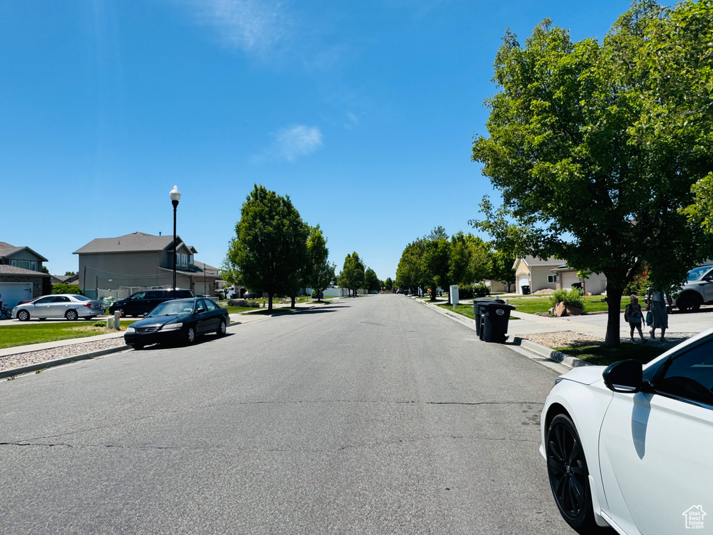 View of asphalt road with sidewalks, street lights, curbs, and a residential view