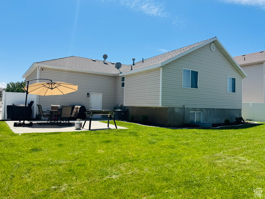 Rear view of property featuring a patio area and roof with shingles
