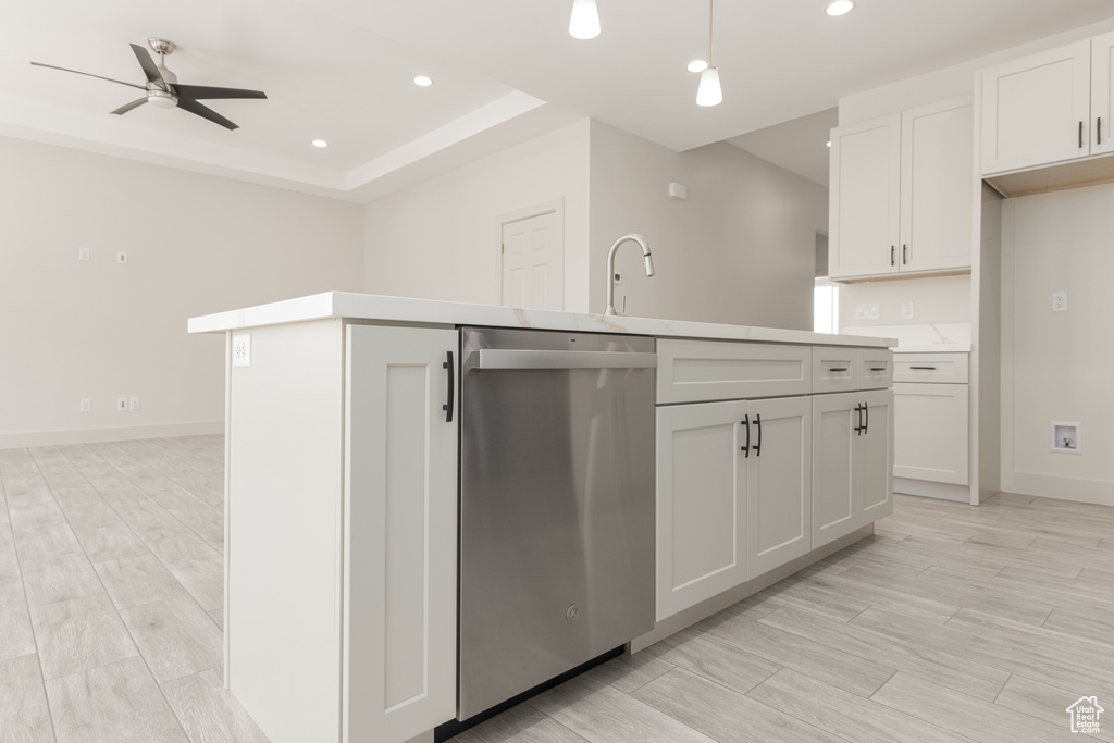 Kitchen featuring stainless steel dishwasher, a center island with sink, a ceiling fan, recessed lighting, and light countertops