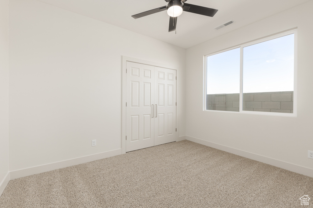 Unfurnished bedroom featuring carpet, baseboards, a closet, and ceiling fan