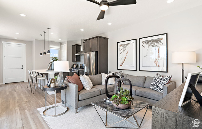 Living room featuring light wood-style floors, ceiling fan, recessed lighting, and baseboards