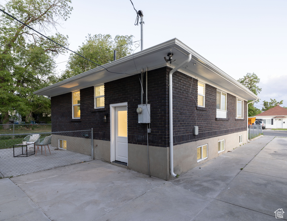 View of property exterior featuring brick siding and a patio