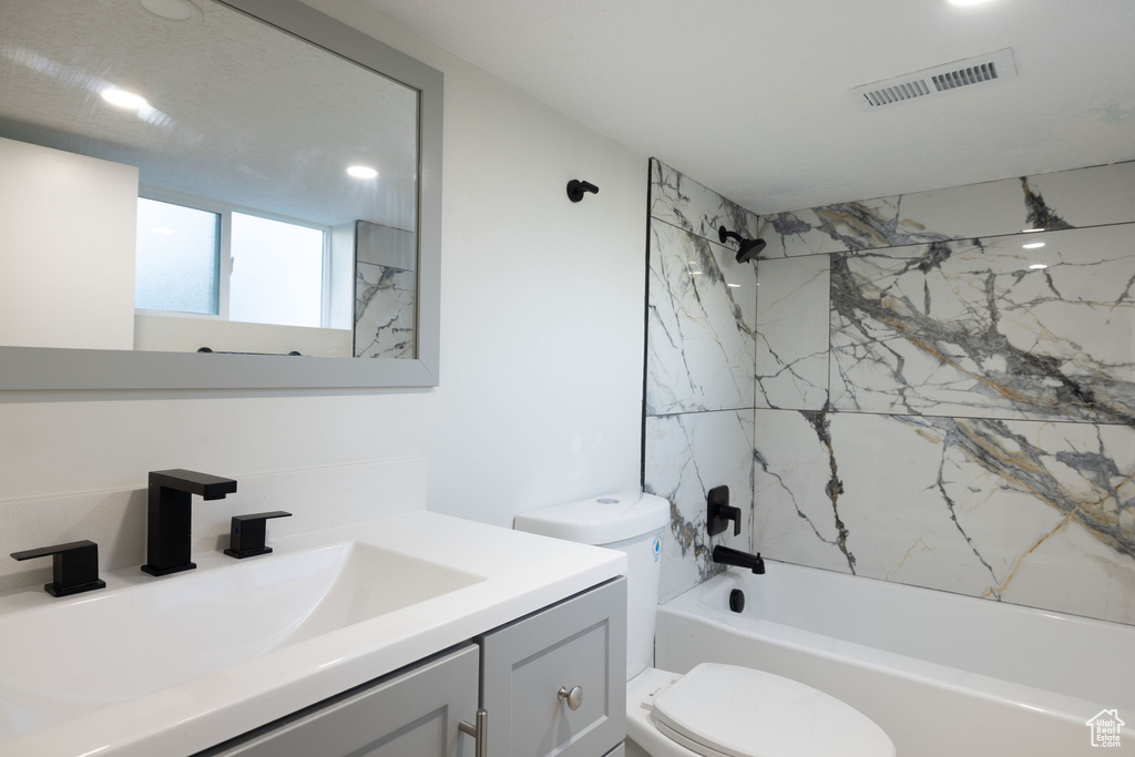 Full bathroom with toilet, vanity, and tub / shower combination