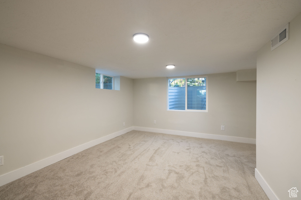 Below grade area with light carpet and baseboards