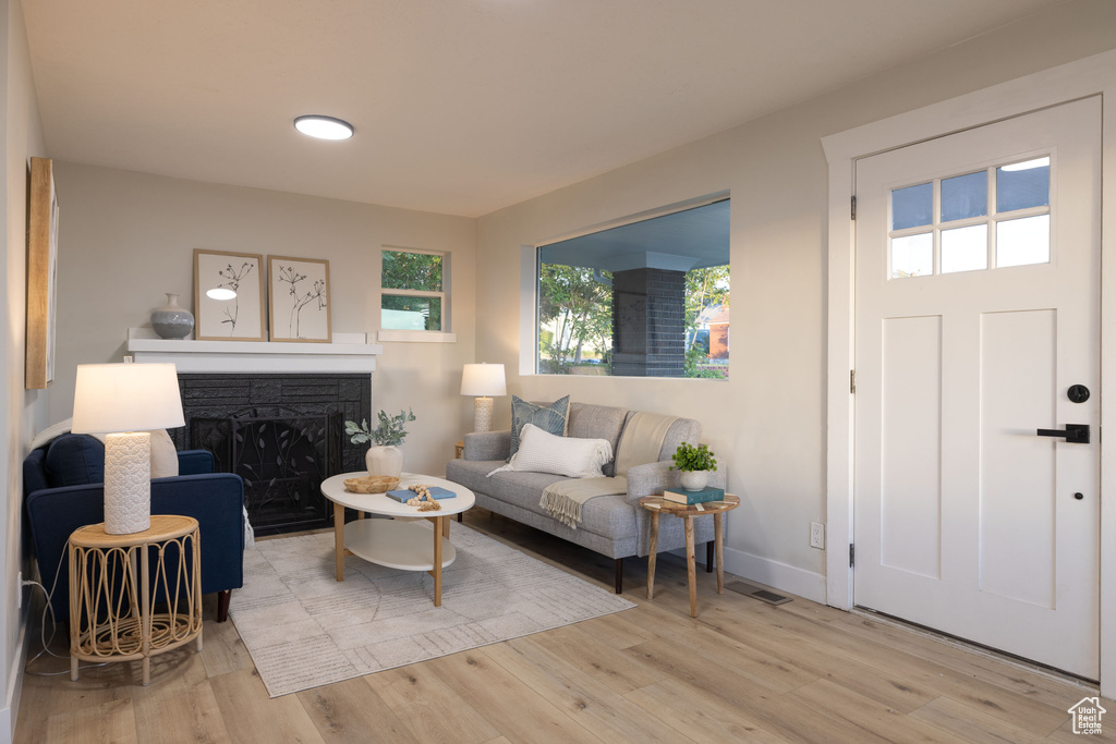 Living area with wood finished floors, a fireplace, and baseboards