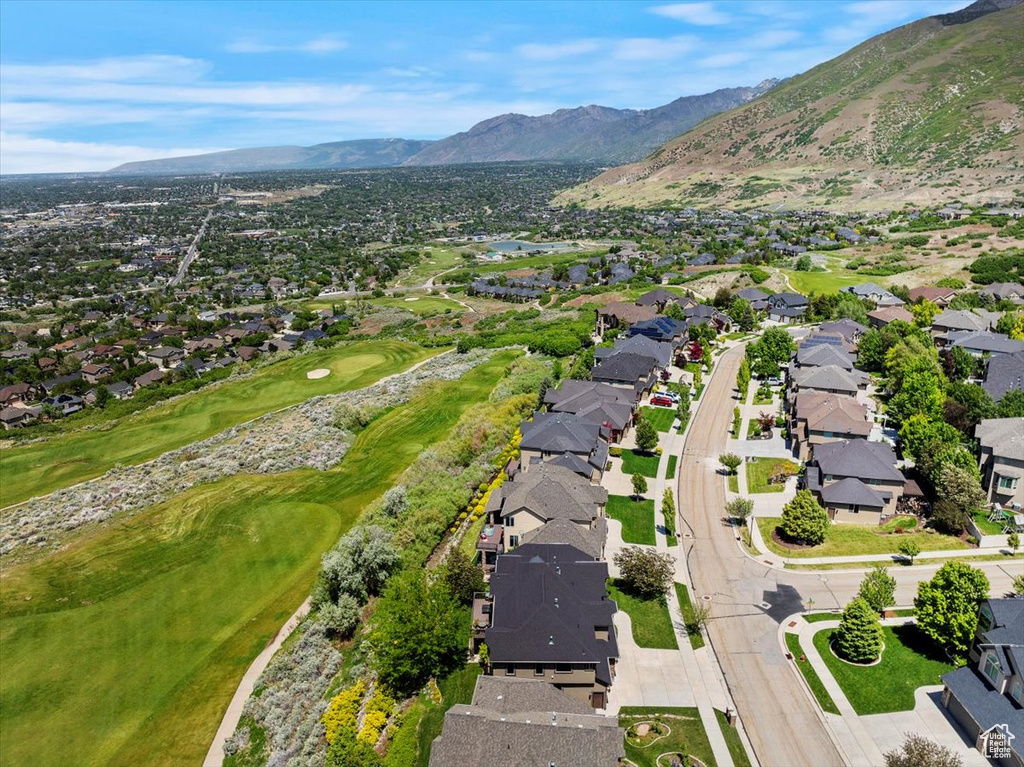 View of property location featuring nearby suburban area, a mountainous background, and a local golf course