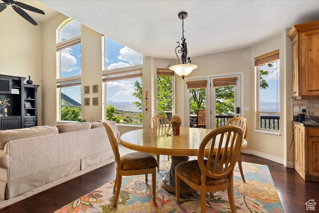 Dining room with ceiling fan, dark wood-type flooring, and baseboards
