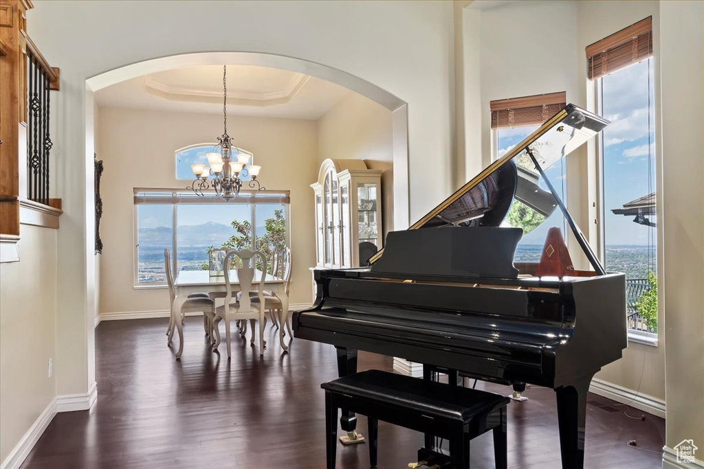 Living area featuring arched walkways, a chandelier, and plenty of natural light