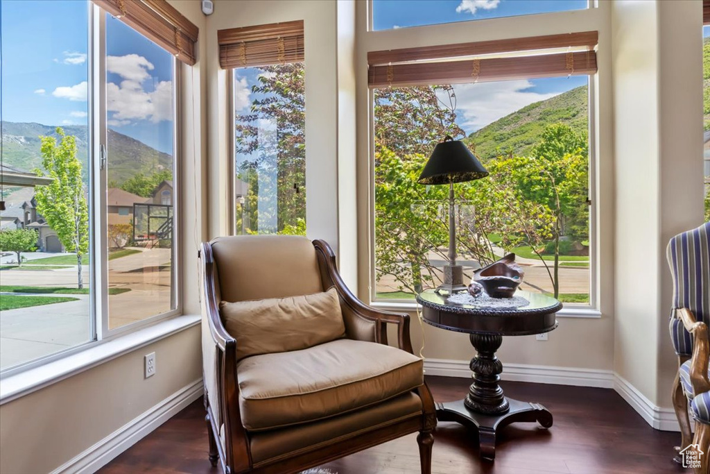 Living area with a mountain view, wood finished floors, and baseboards