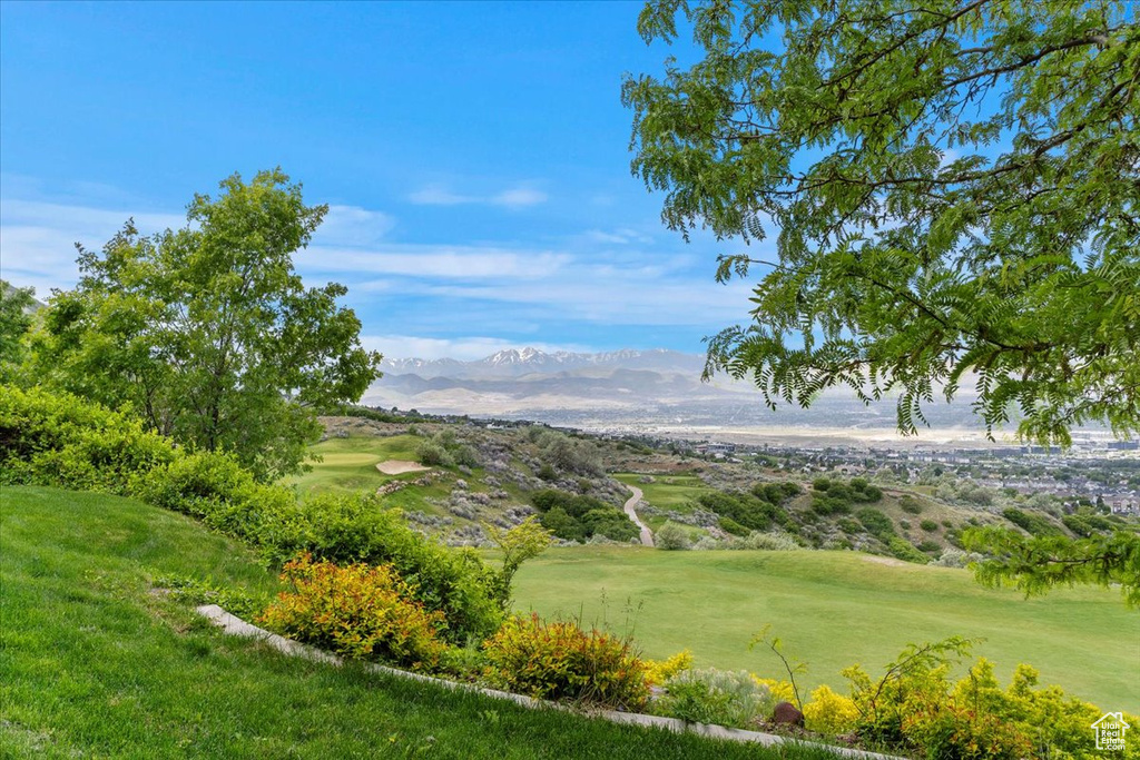 View of home\'s community with a mountain view, view of golf course, and a yard
