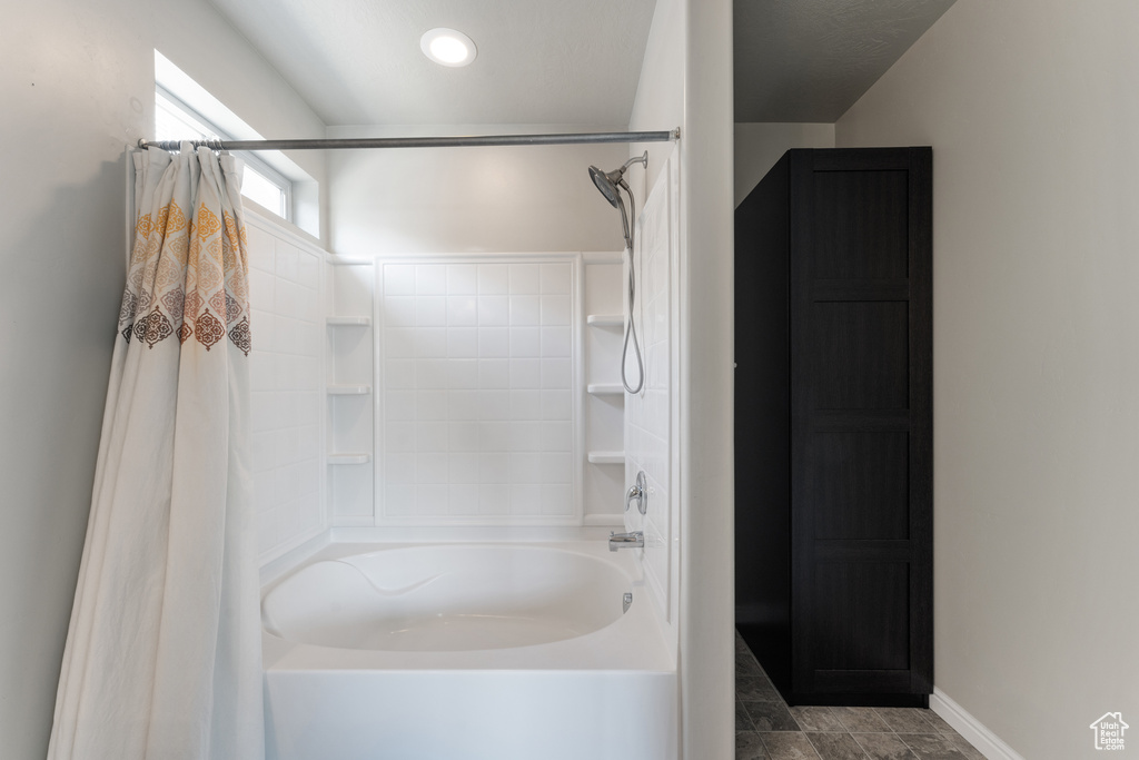 Bathroom with shower / bathtub combination with curtain and baseboards