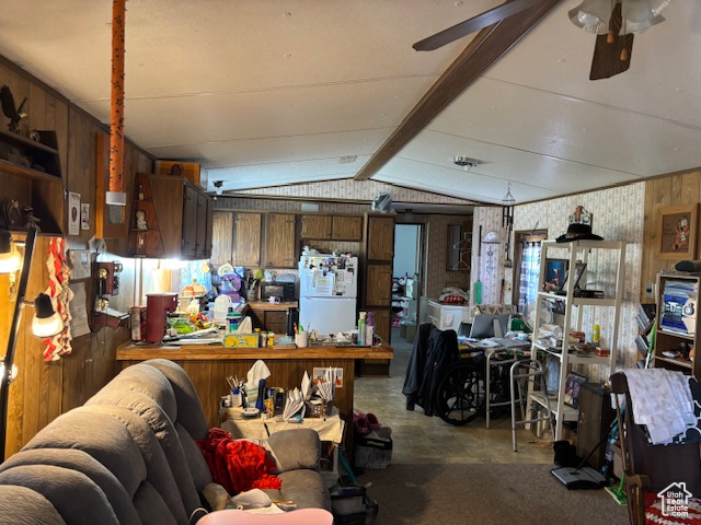 Miscellaneous room featuring vaulted ceiling, wood walls, and ceiling fan