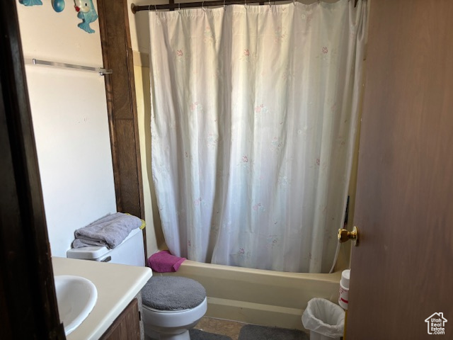 Full bathroom with toilet, vanity, and shower / bath combo