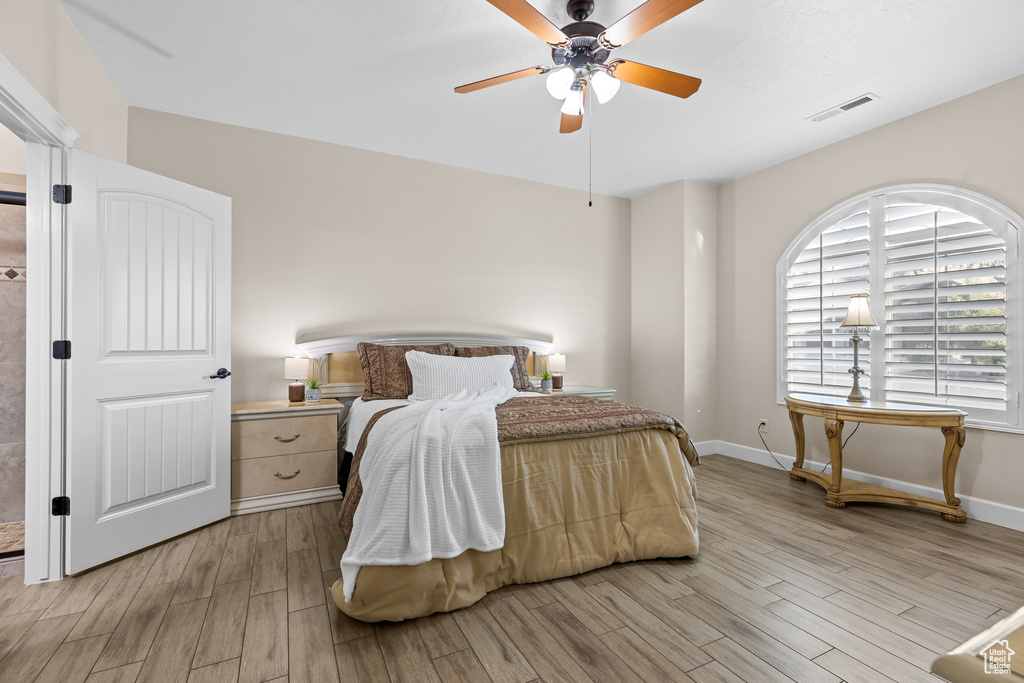 Bedroom with light wood-type flooring, baseboards, and ceiling fan