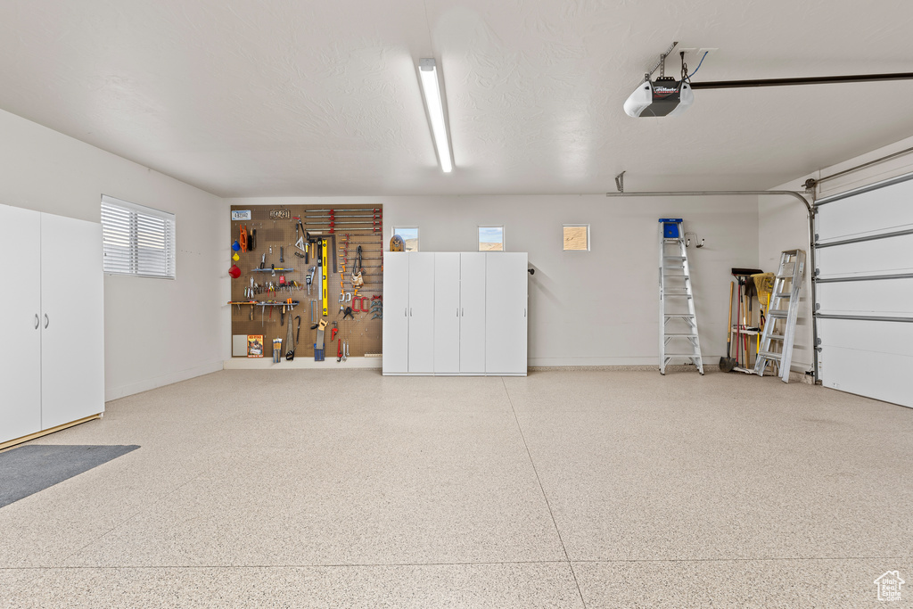 Garage featuring a garage door opener and a workshop area