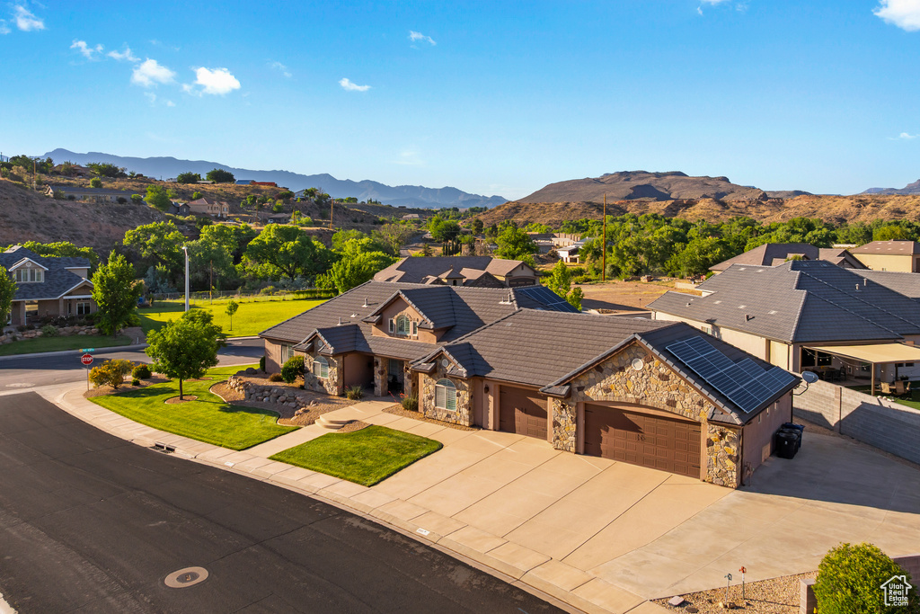 Single story home with stone siding, a mountain view, driveway, a garage, and a tiled roof