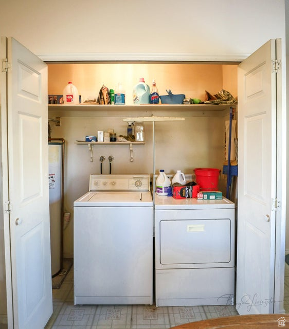 Laundry room featuring washing machine and clothes dryer and water heater