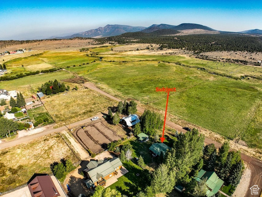 Aerial view of property\'s location featuring rural landscape and a mountainous background
