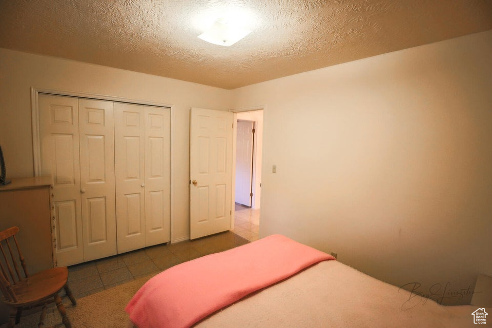 Bedroom with a closet and a textured ceiling