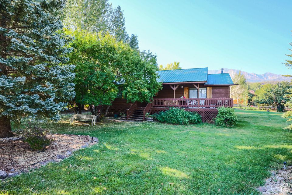 Back of property featuring a yard, metal roof, and a mountain view