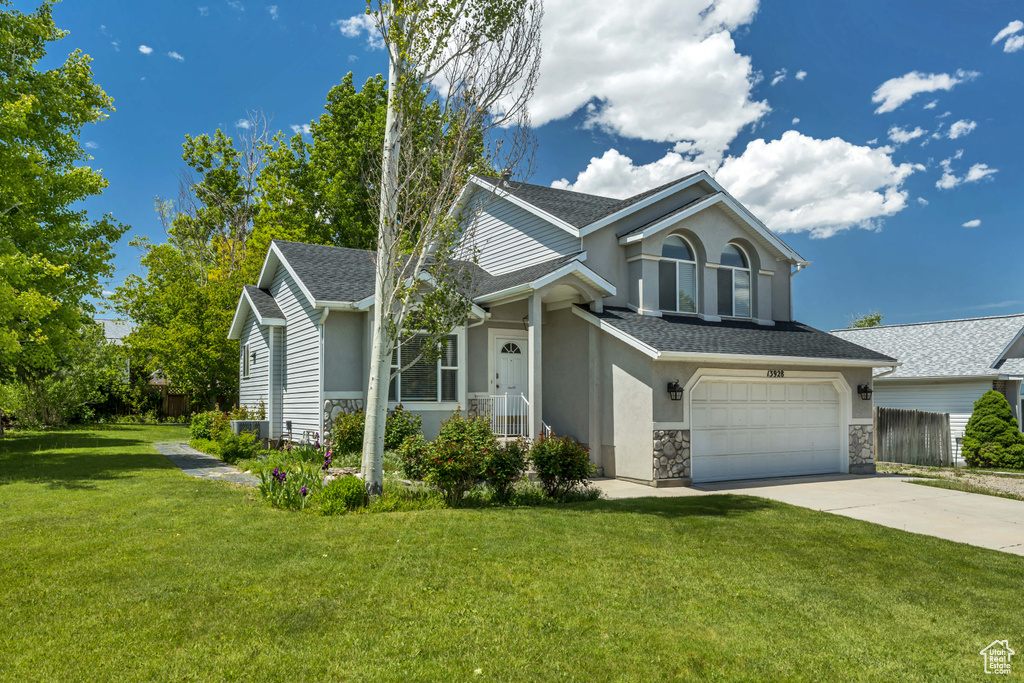 View of front of property featuring stucco siding, roof with shingles, concrete driveway, stone siding, and an attached garage
