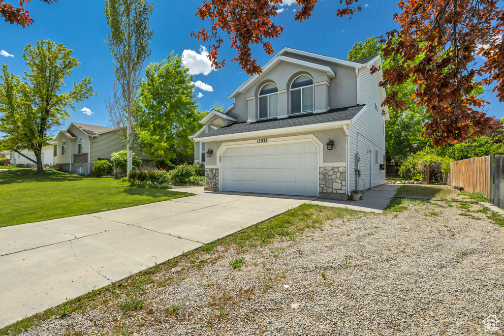 Traditional-style home featuring concrete driveway, a garage, and stone siding