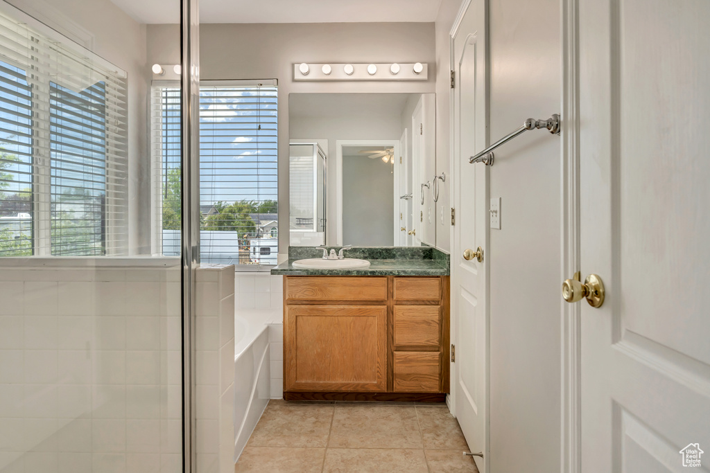 Full bath featuring vanity, tile patterned flooring, healthy amount of natural light, and a bath