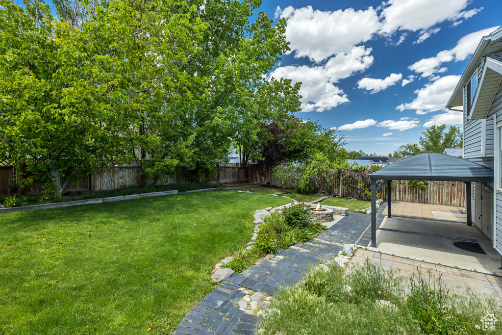 View of yard featuring a fire pit, a gazebo, and a patio area