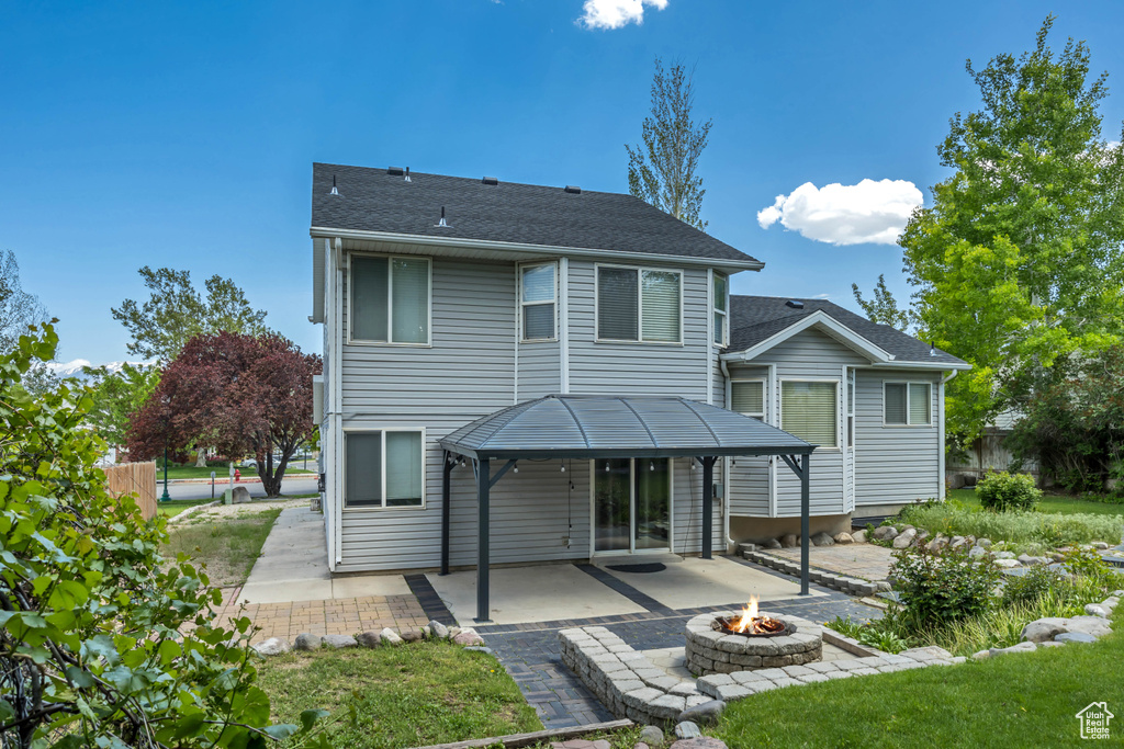 Back of property featuring a fire pit, a patio, and a gazebo