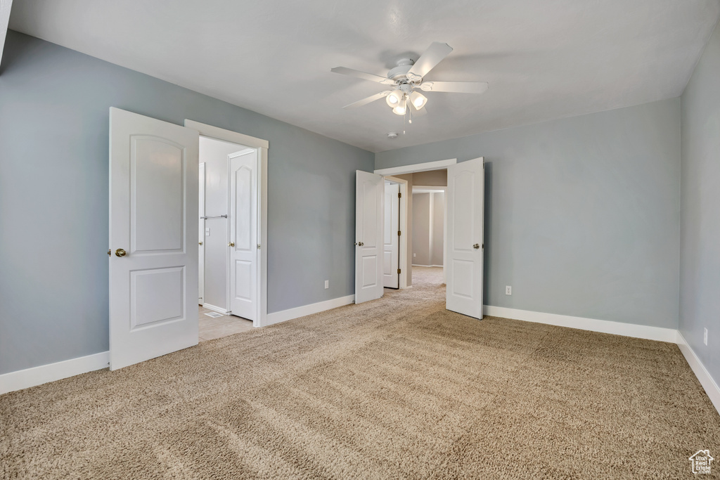 Unfurnished bedroom with carpet floors, baseboards, and a ceiling fan