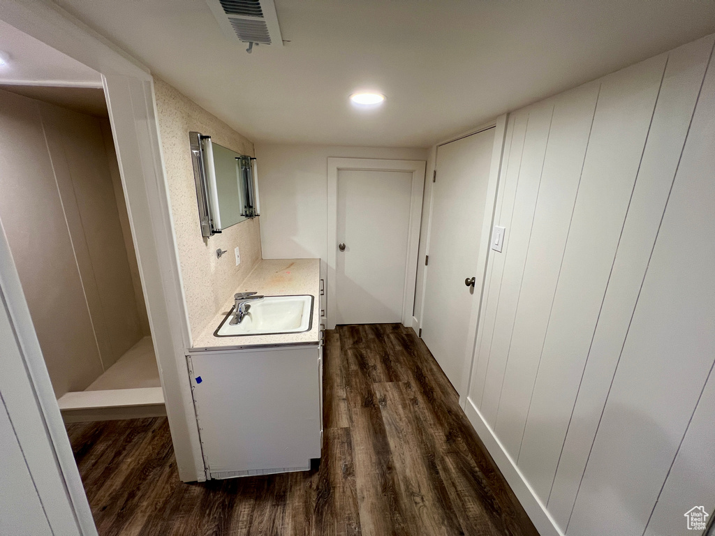 Hall with dark wood-style floors, a sink, and recessed lighting
