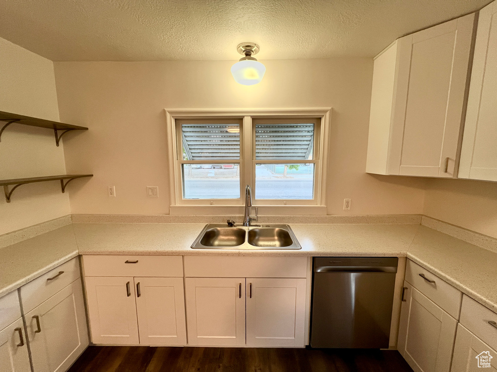 Kitchen featuring dishwasher, a sink, open shelves, white cabinetry, and a textured ceiling