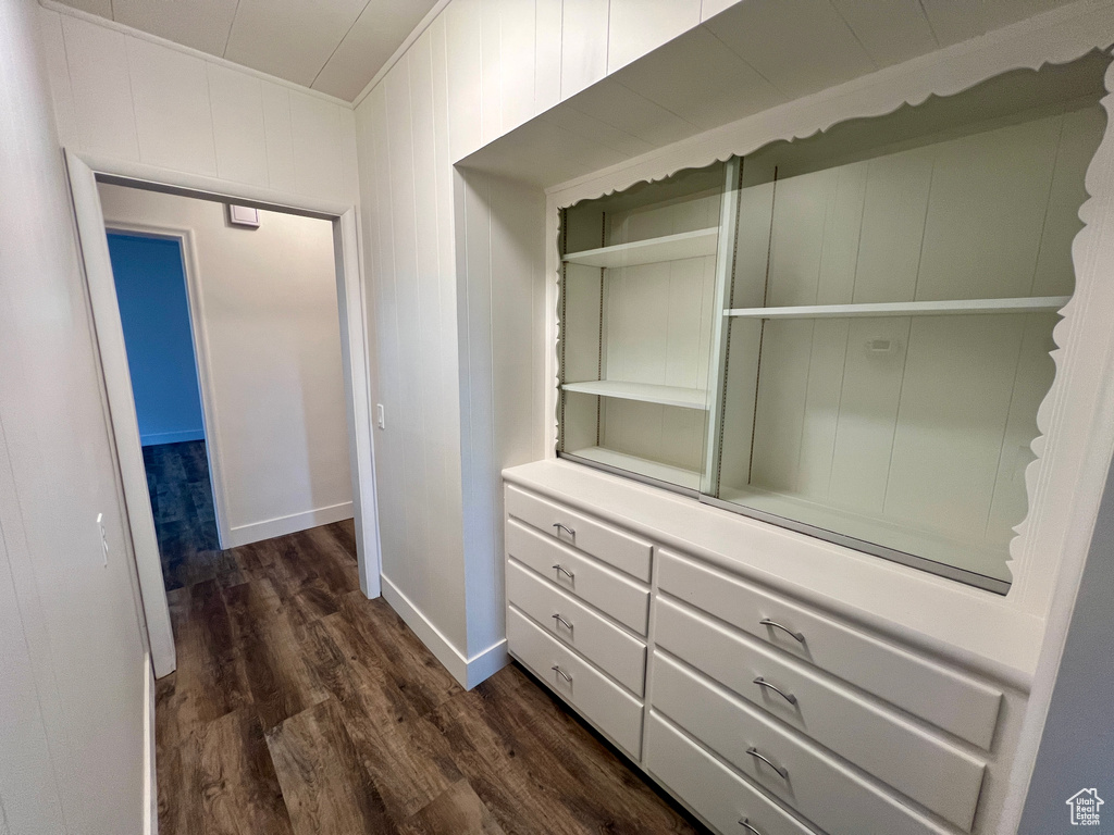 Hall with dark wood-style floors, baseboards, and crown molding