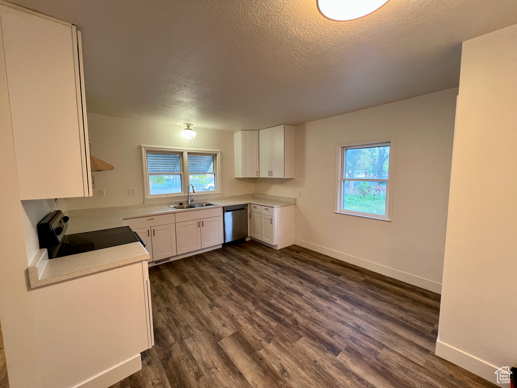 Kitchen featuring electric range oven, a sink, dishwasher, dark wood-style flooring, and a textured ceiling