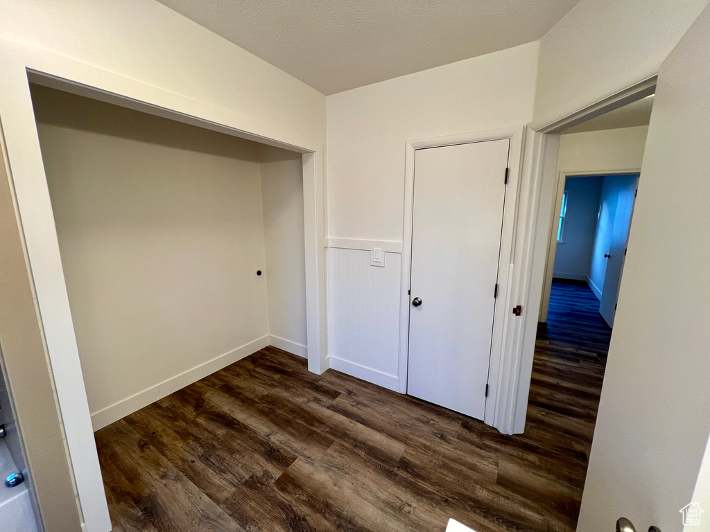 Unfurnished bedroom featuring dark wood-type flooring and a closet