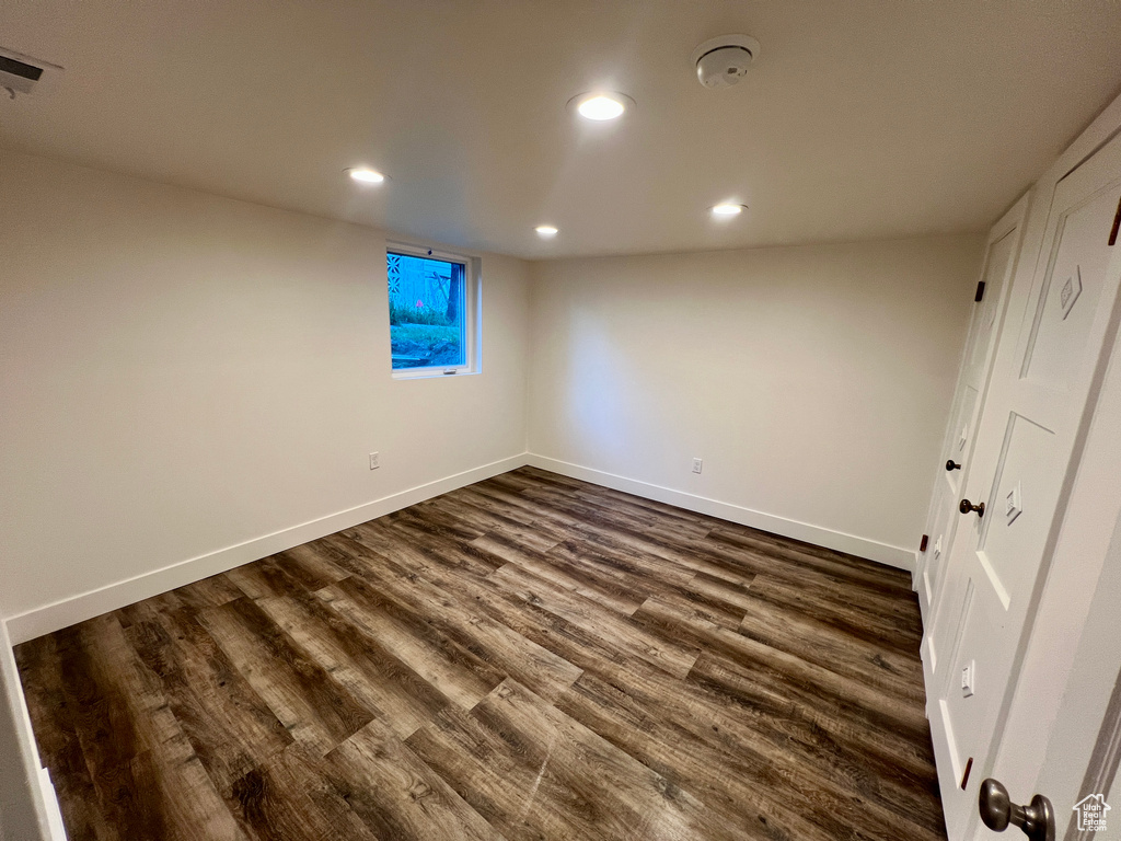 Empty room featuring recessed lighting, dark wood finished floors, baseboards, and a smoke detector