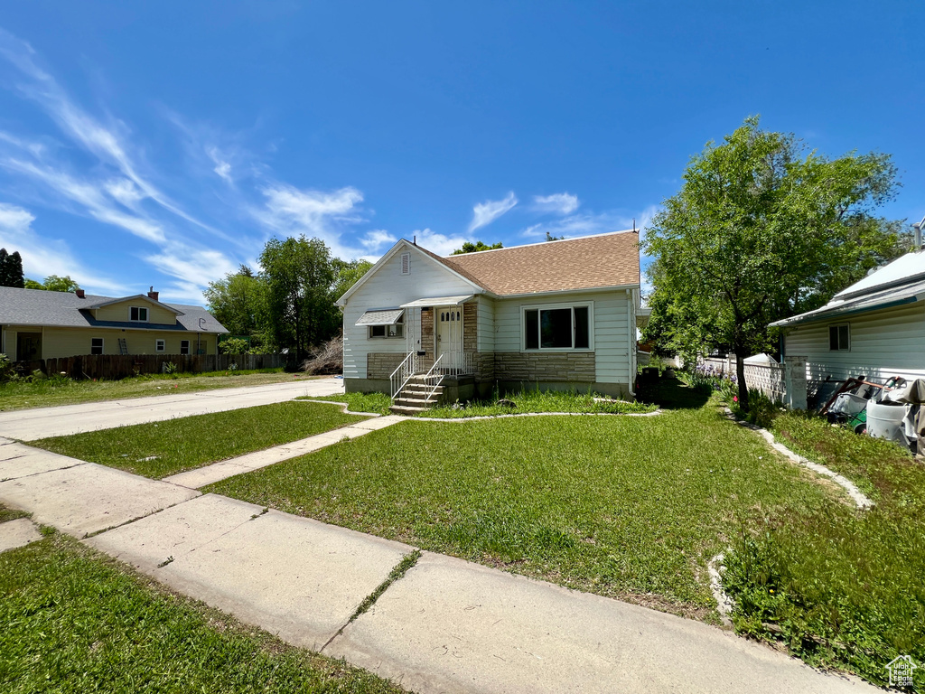 Bungalow featuring a shingled roof and driveway