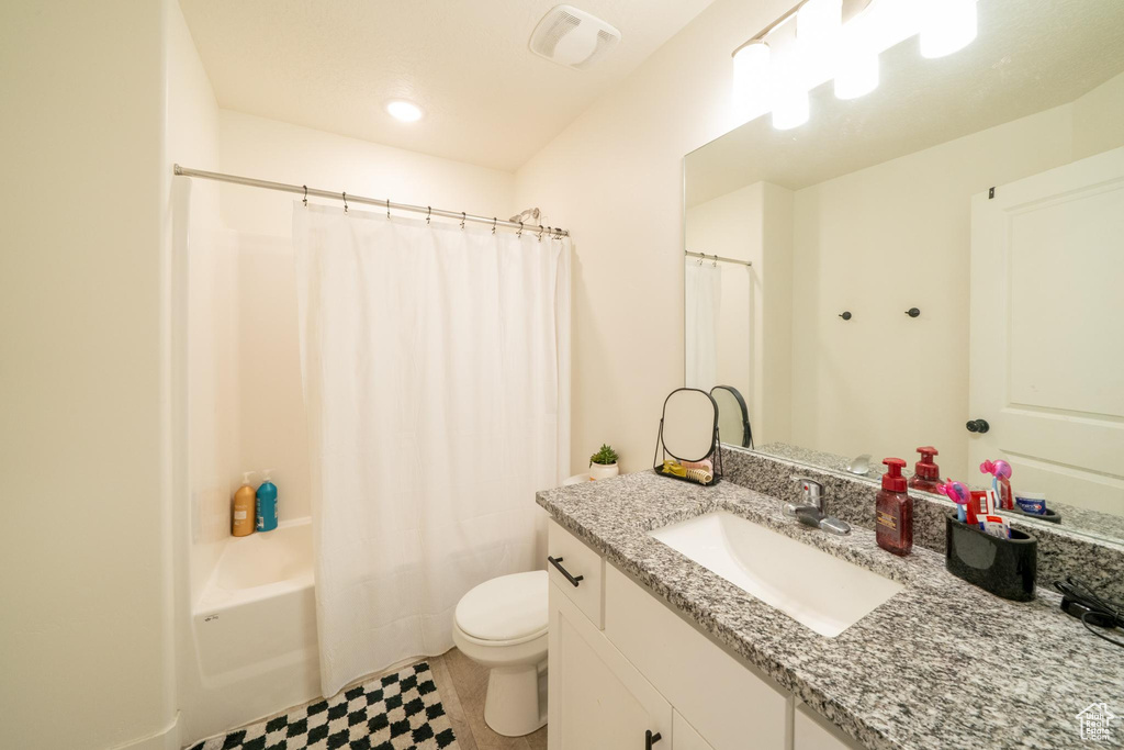 Full bathroom featuring vanity, toilet, and shower / tub combo