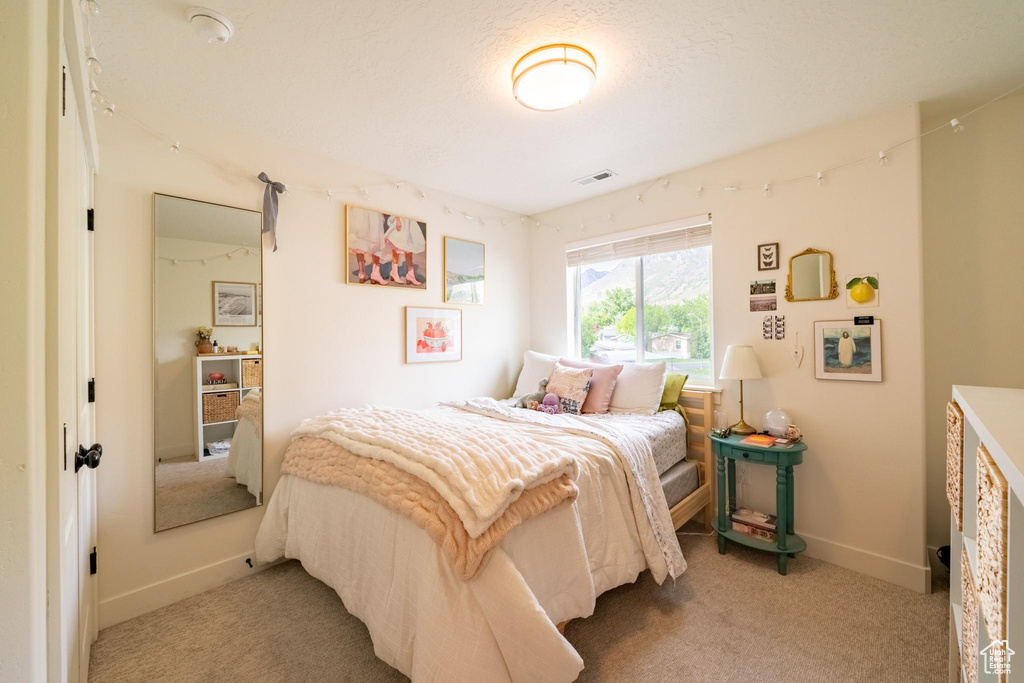 Bedroom with light colored carpet and baseboards