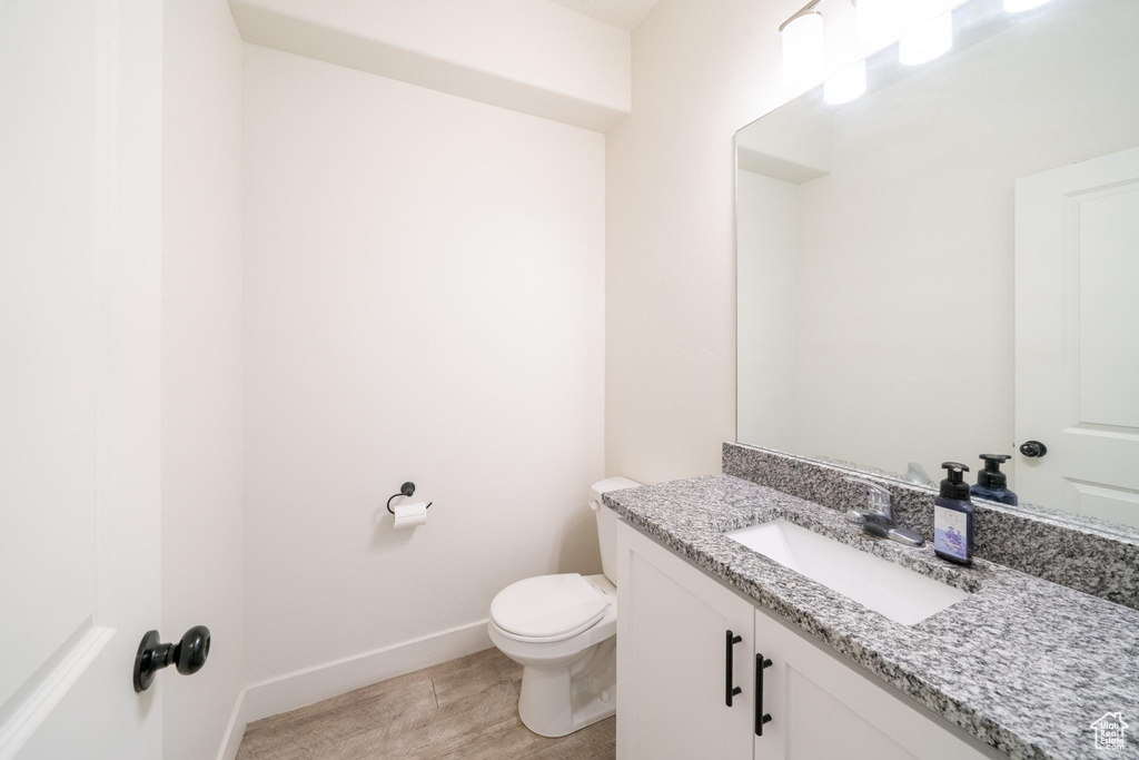 Bathroom with vanity, toilet, and baseboards
