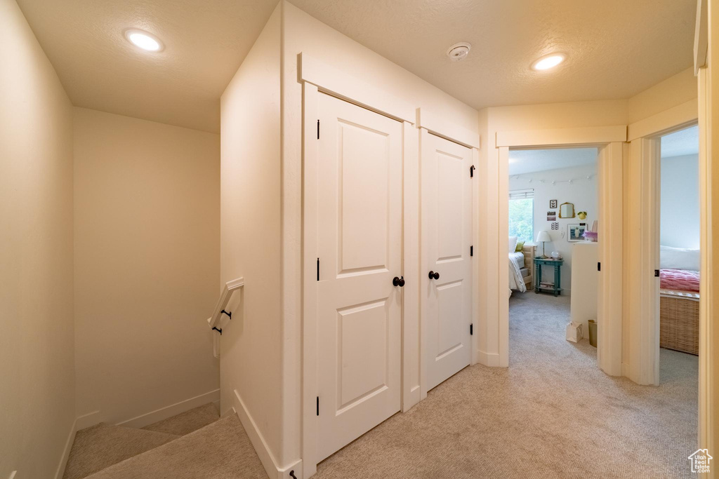 Corridor featuring light colored carpet, recessed lighting, and baseboards
