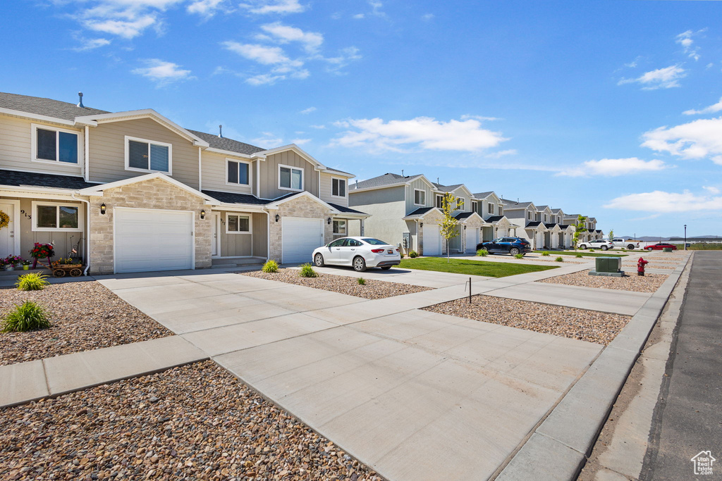 View of yard with a residential view, driveway, and a garage