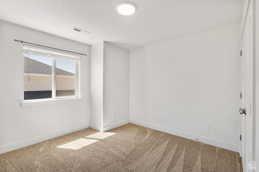 Carpeted empty room with baseboards