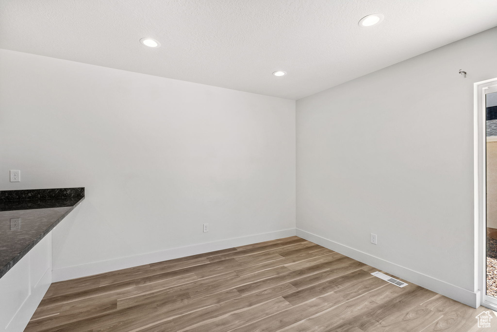 Unfurnished dining area with light wood-style floors, baseboards, and recessed lighting
