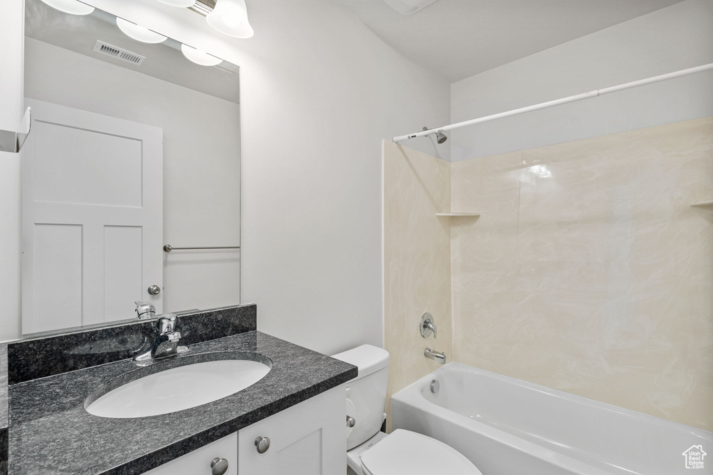 Bathroom featuring toilet, washtub / shower combination, and vanity