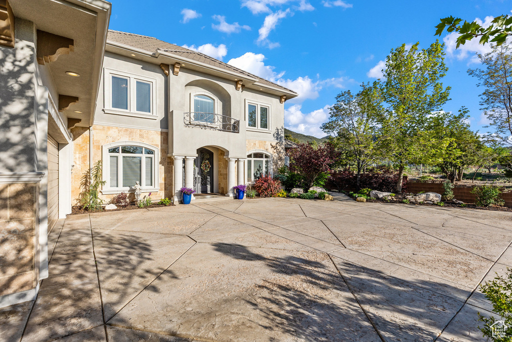 View of front of home featuring a balcony and stucco siding