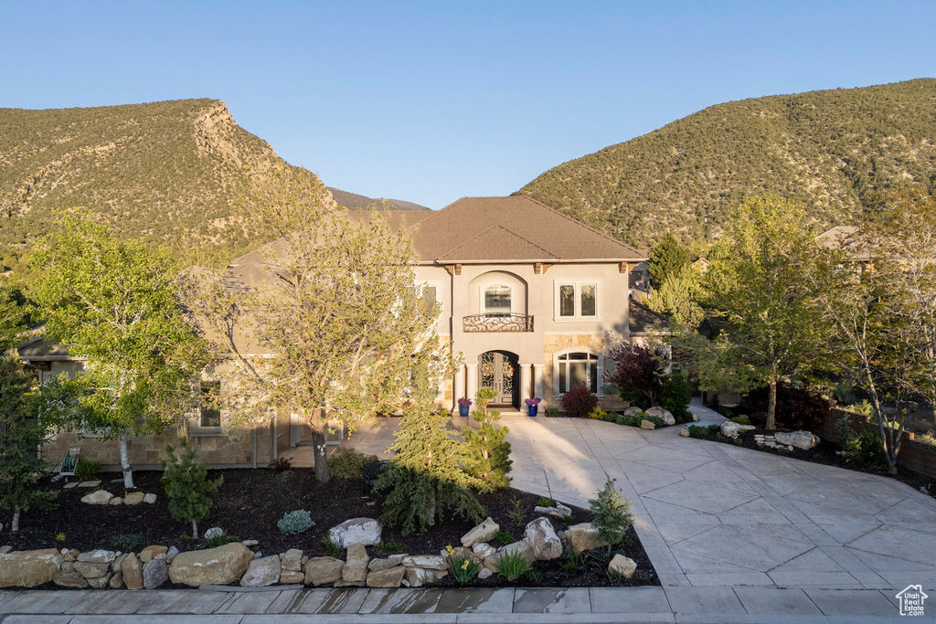 View of front of house featuring stucco siding, a mountain view, and concrete driveway