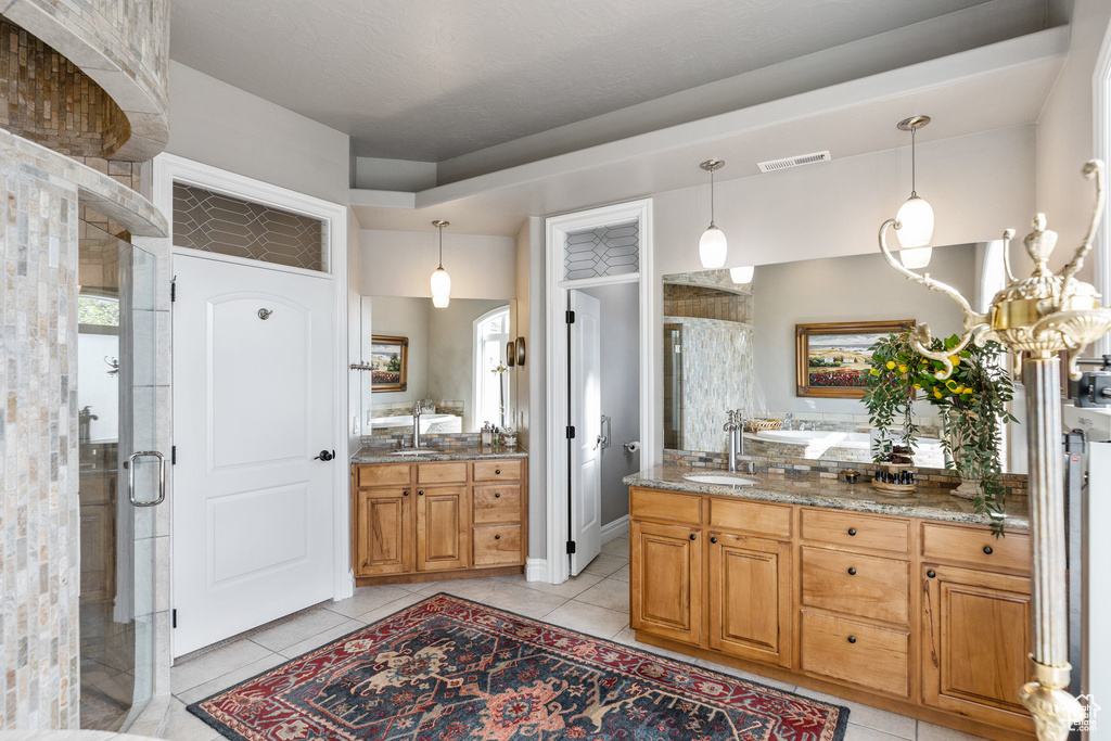 Full bathroom featuring a stall shower, vanity, and tile patterned flooring